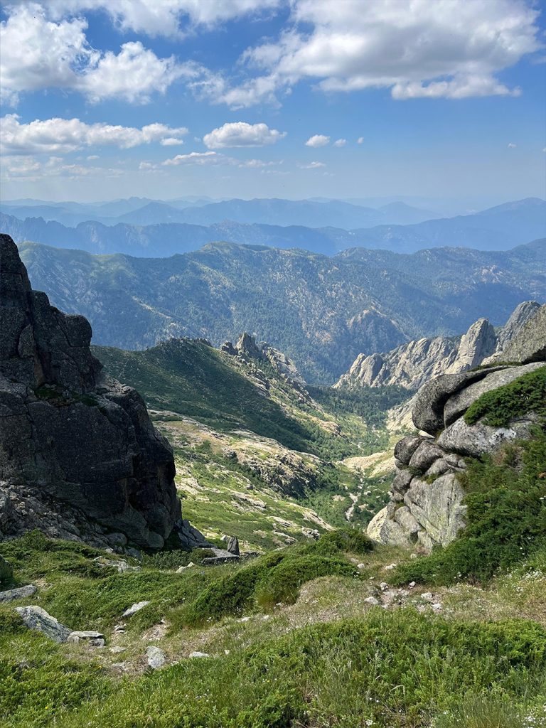 Vue panoramique sur des montagnes et vallées verdoyantes, cadre inspirant pour relever des défis personnels
