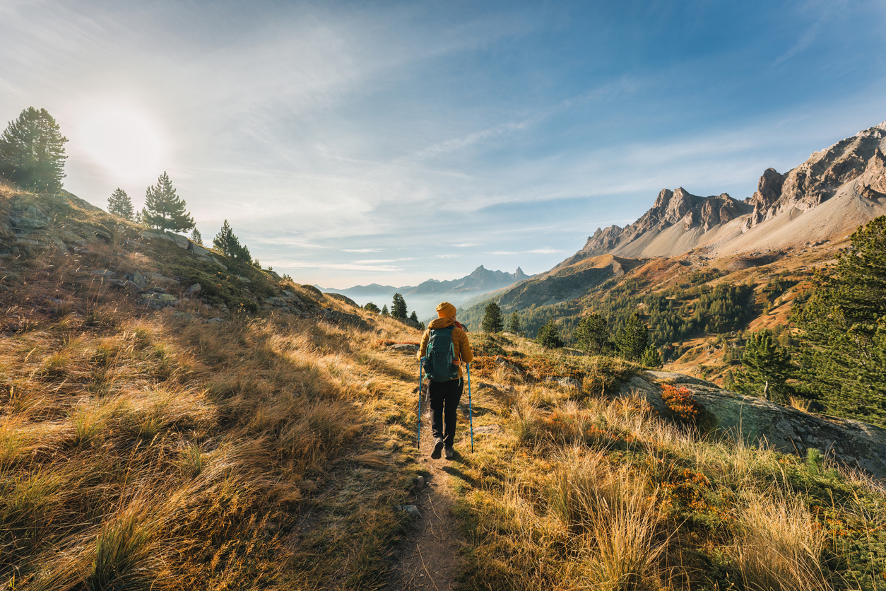 Randonneuse trekking sur un sentier de randonnée dans la vallée de Claree en automne dans les Alpes françaises, France